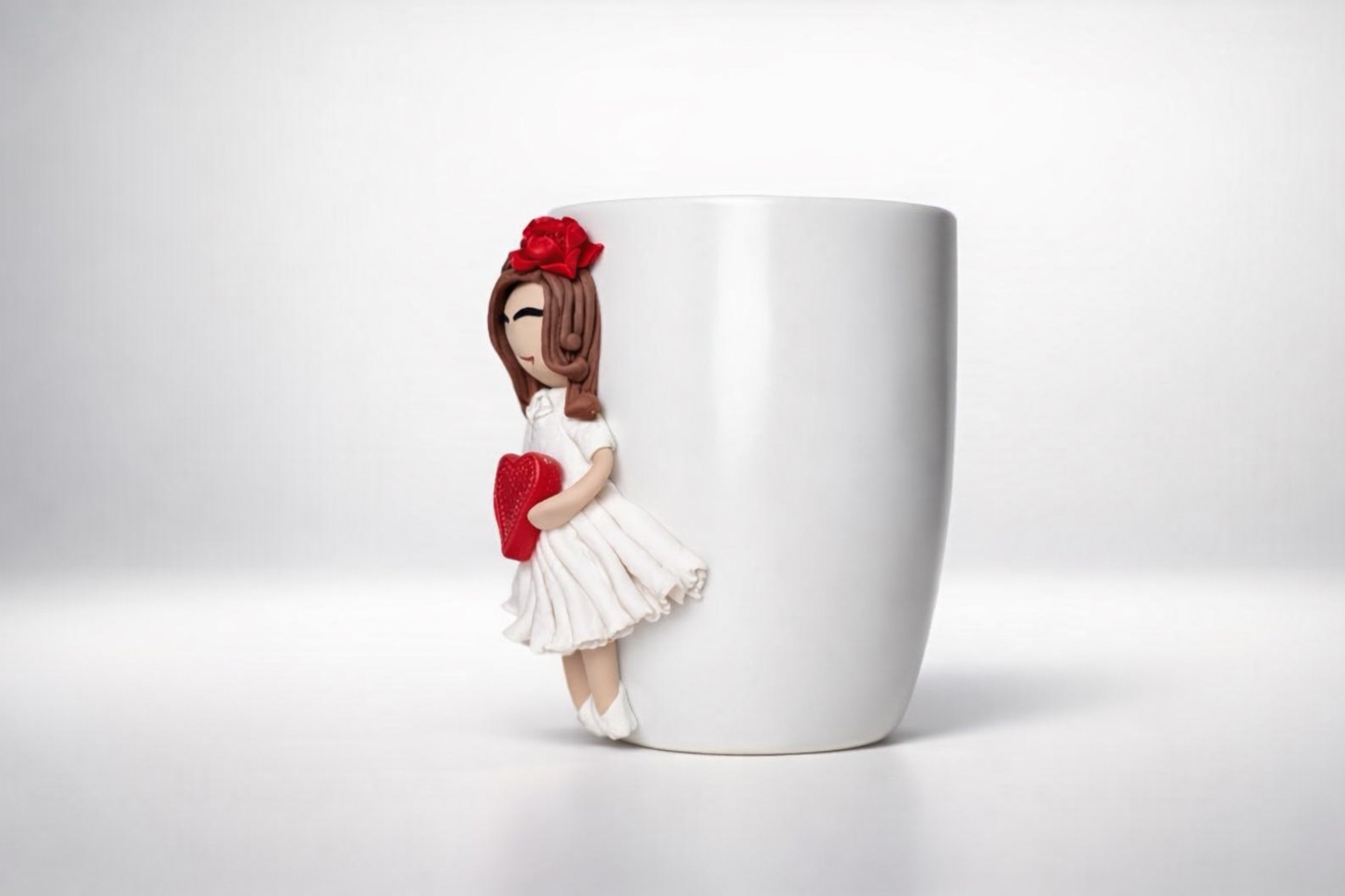 Ceramic mug with hand-modeled 3D doll figurine with heart made of polymer clay 