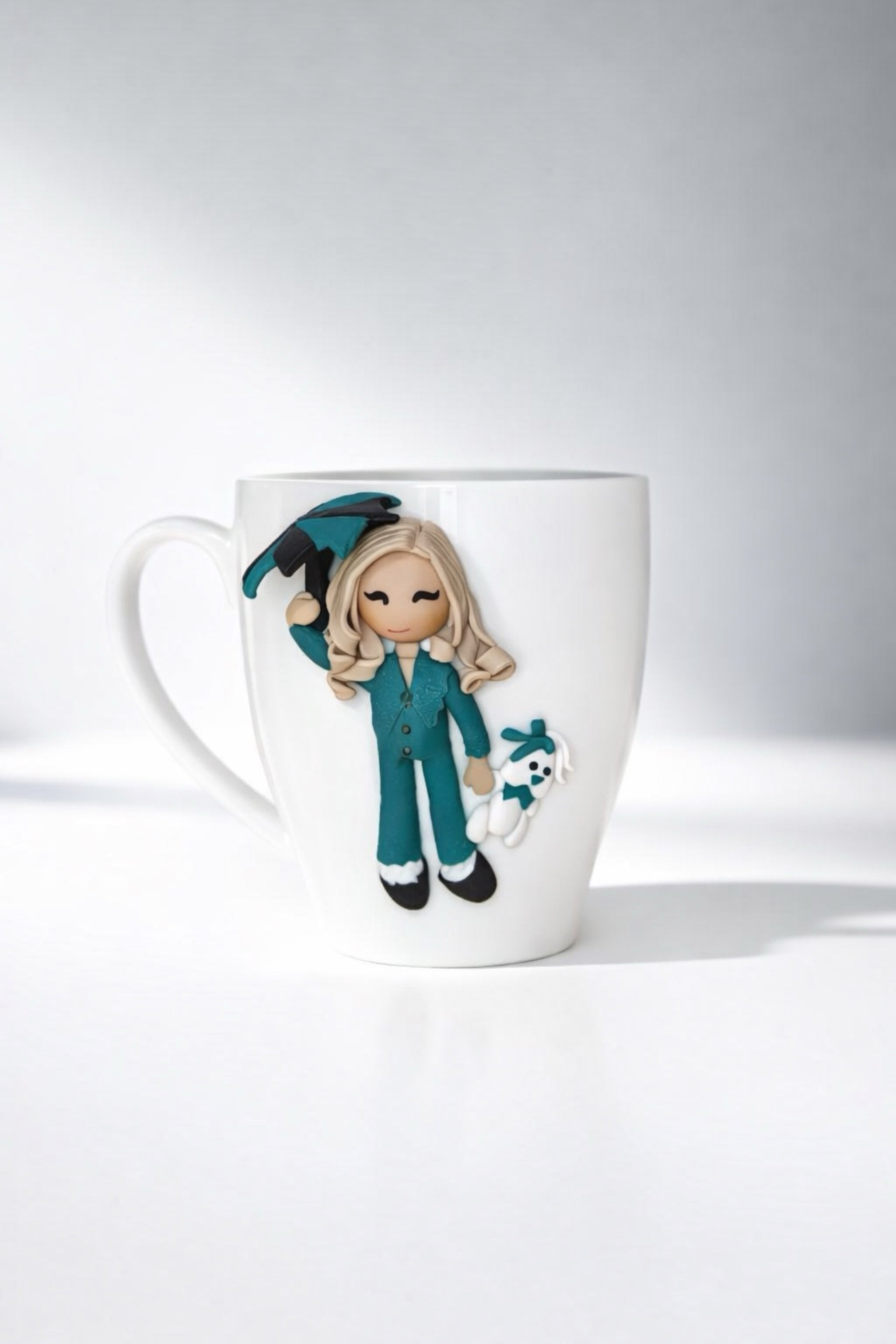 Ceramic mug with hand-modeled 3D doll figurine with umbrella and bunny made of polymer clay