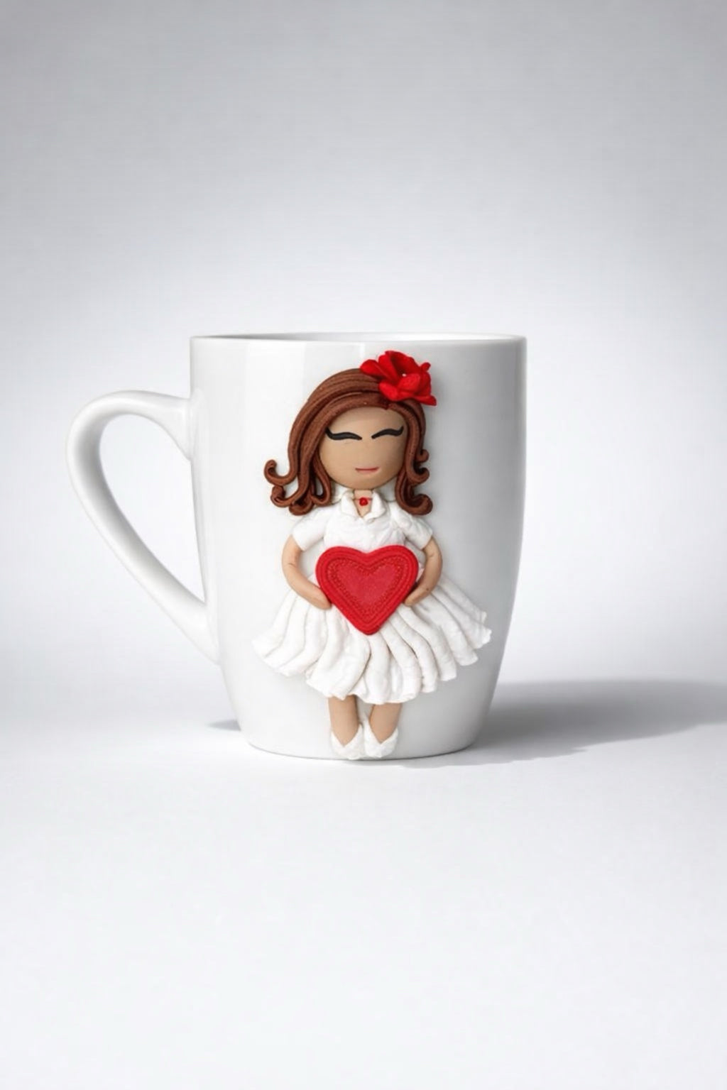 Ceramic mug with hand-modeled 3D doll figurine with heart made of polymer clay 