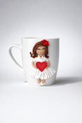 Ceramic mug with hand-modeled 3D doll figurine with heart made of polymer clay 